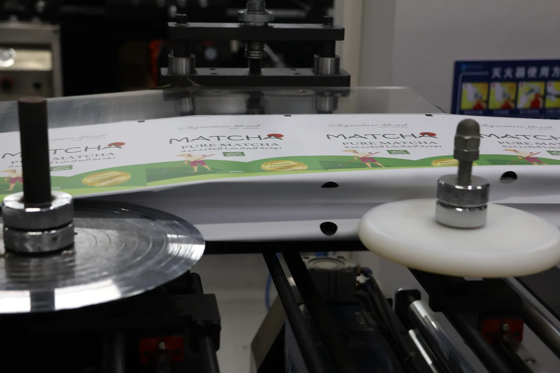 Printed matcha pouch artwork moving through a packaging production machine
